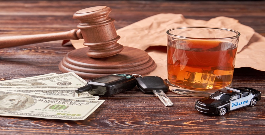 DUI concept: judge gavel, alcohol, money, keys, toy car.