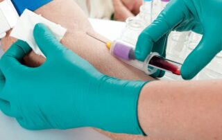 Healthcare worker drawing blood from arm