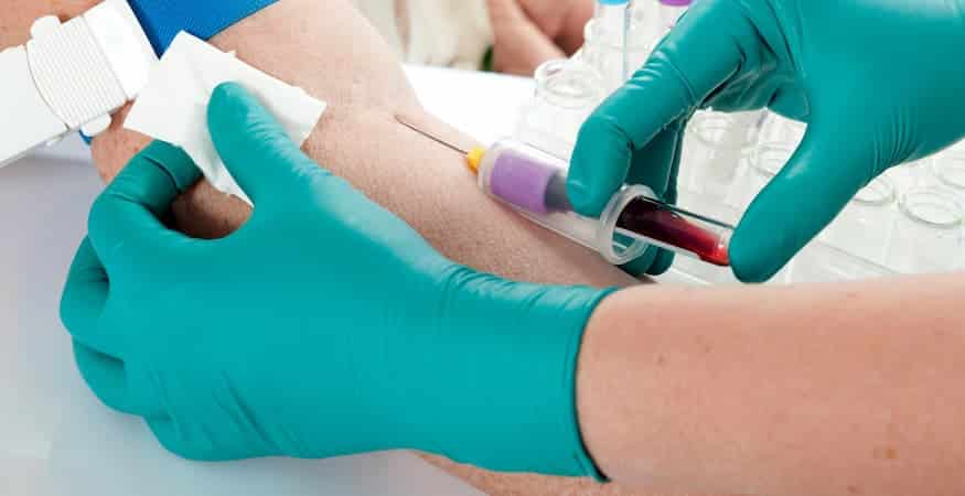 Healthcare worker drawing blood from arm