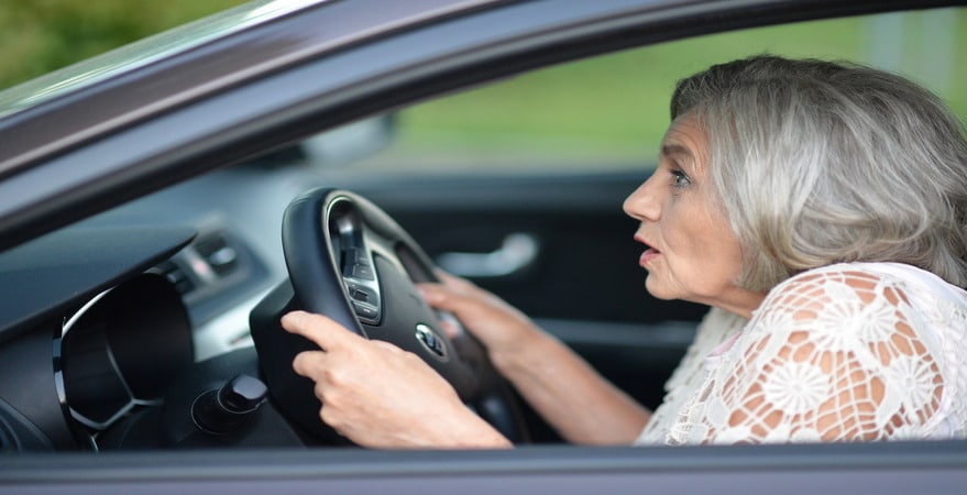An elderly driver looks startled behind the wheel—raising the question: Can Age Affect DUI Tests? DUI Law Firm Denver explains how age may play a role.
