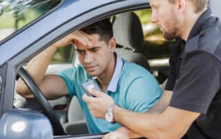 Driver taking breathalyzer test during traffic stop