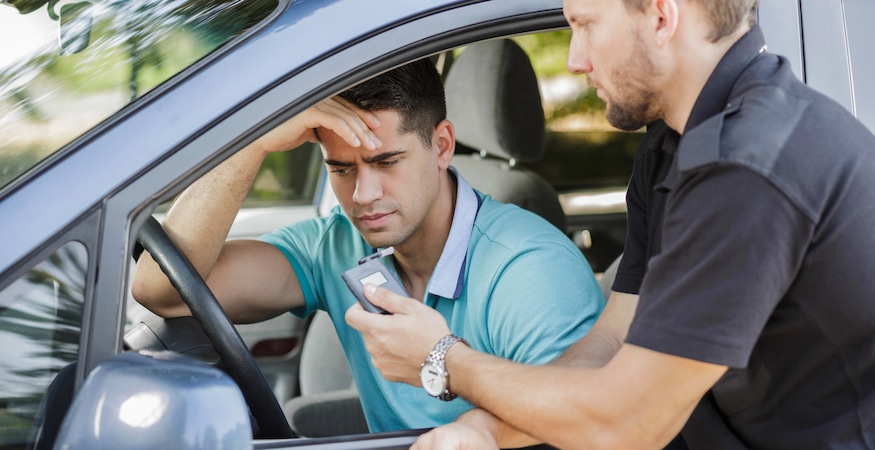 Driving Under the Influence of Dehydration Driver taking breathalyzer test during traffic stop