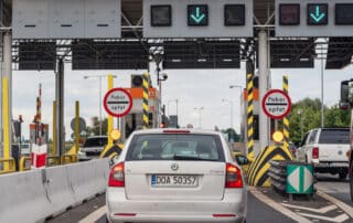 Cars passing through highway toll booth plaza