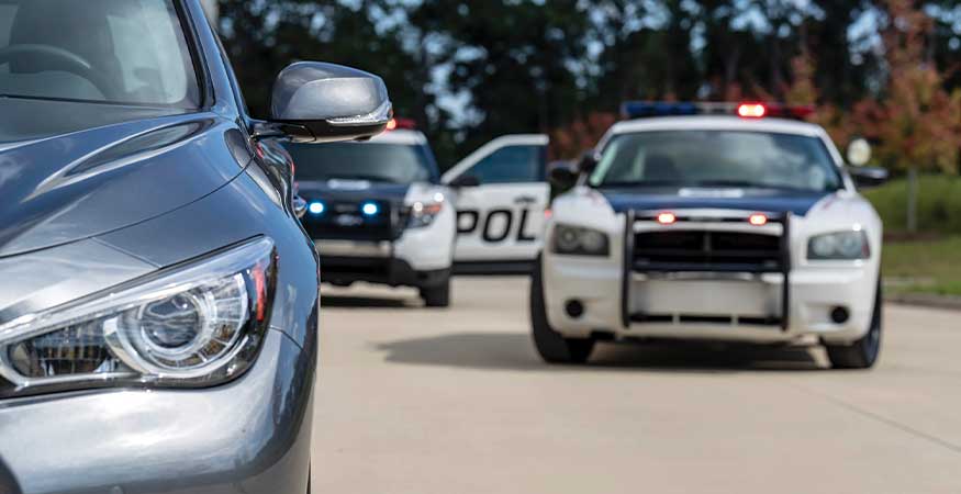 Was the Stop Legal image showing a driver pulled over during a traffic stop while a police officer approaches the vehicle. The scene illustrates a DUI defense question—whether law enforcement had reasonable suspicion or probable cause to legally stop the driver.