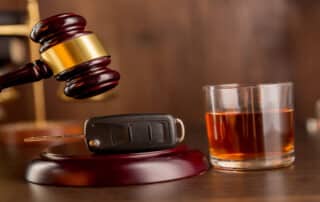 DUI Law Firm Denver: Whiskey, car keys, and handcuffs illustrate what determines the level of a DUI fine under Colorado DUI Law.
