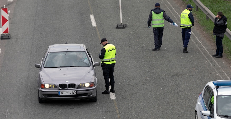 Police officer stopping car at road checkpoint